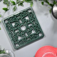 Green Square Cast Iron Trivet in Situ on Grey Surface