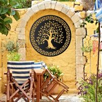 Round "Olive Tree" Wall Art on a Yellow Wall in the Garden