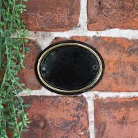 Polished Brass & Black Oval House Number Sign in Use Outdoors on a Wall