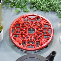 Red Heavy Duty Cast Iron Round Trivet in Situ on a Table