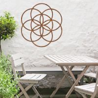 Rustic "Seed of Life" Steel Wall Art in Situ Outdoors by a Wooden Table and Chairs Set