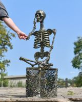 Scale image of brushed gold skeleton detail on outdoor sculpture