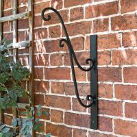 Black Scrolled Hanging Basket Bracket in Situ on a Black Wall