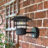 Side View of the "Skive" Black Contemporary Wall Light Mounted on a Brick Wall