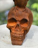 Close up of skull detail on cast iron garden statue