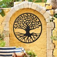 Black Round "Tree of Life" Wall Art on a Yellow Garden Wall
