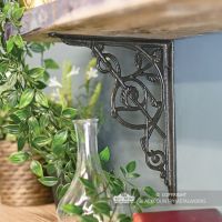 Trellis Iron Shelf Bracket in Use Mounted onto a Blue Wall