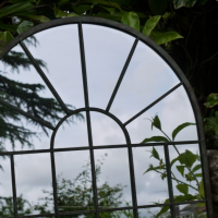 Close up of Arched Metal Mirror in Garden