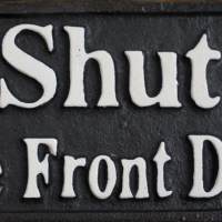 Close up of Cast Iron Sign with White Lettering 