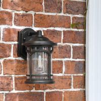 Bronze wall light in situ next to door frame 