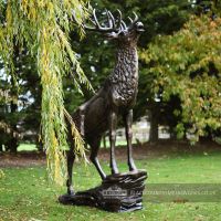 Beautiful Highland stag Sculpture in estate garden next to willow tree