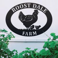 Hen & Chicks Iron Oval House Sign on a White Wall