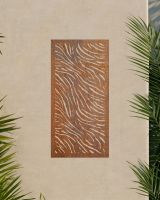 "Rust Finish Zebra print Garden Wall Art" on an outdoor wall surrounded by palm leaves 
