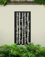 Black "Bamboo Garden Wall Art" on a cream garden wall amongst plants