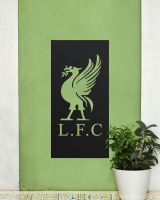 Black "Liver Bird Wall Art" on a green garden wall next to a potted plant