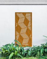 Rustic "Geometric Cube Wall Art" on a white garden wall behind garden plants 