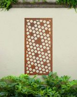 Rustic" Honeycomb Pattern Wall Art" on a cream garden wall behind garden plants