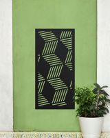 Black "Geometric Cube Wall Art" on a green wall next to a potted plant