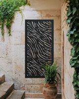 "Black Zebra Print Garden Wall Art" mounted on a brick wall of a house next to stairs 