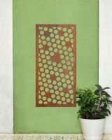 Rustic" Honeycomb Pattern Wall Art" mounted on a green wall next to a potted plant