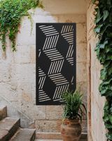 Black "Geometric Cube Wall Art" on a brick wall nest to stone steps