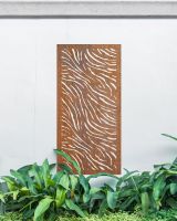 "Rust Finish Zebra print Garden Wall Art" on a white garden wall amongst garden plants