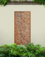 "Rust Finish Zebra print Garden Wall Art" on a cream outdoor wall amongst plants