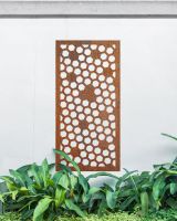 Rustic" Honeycomb Pattern Wall Art" mounted on a white garden wall surrounded by garden plants
