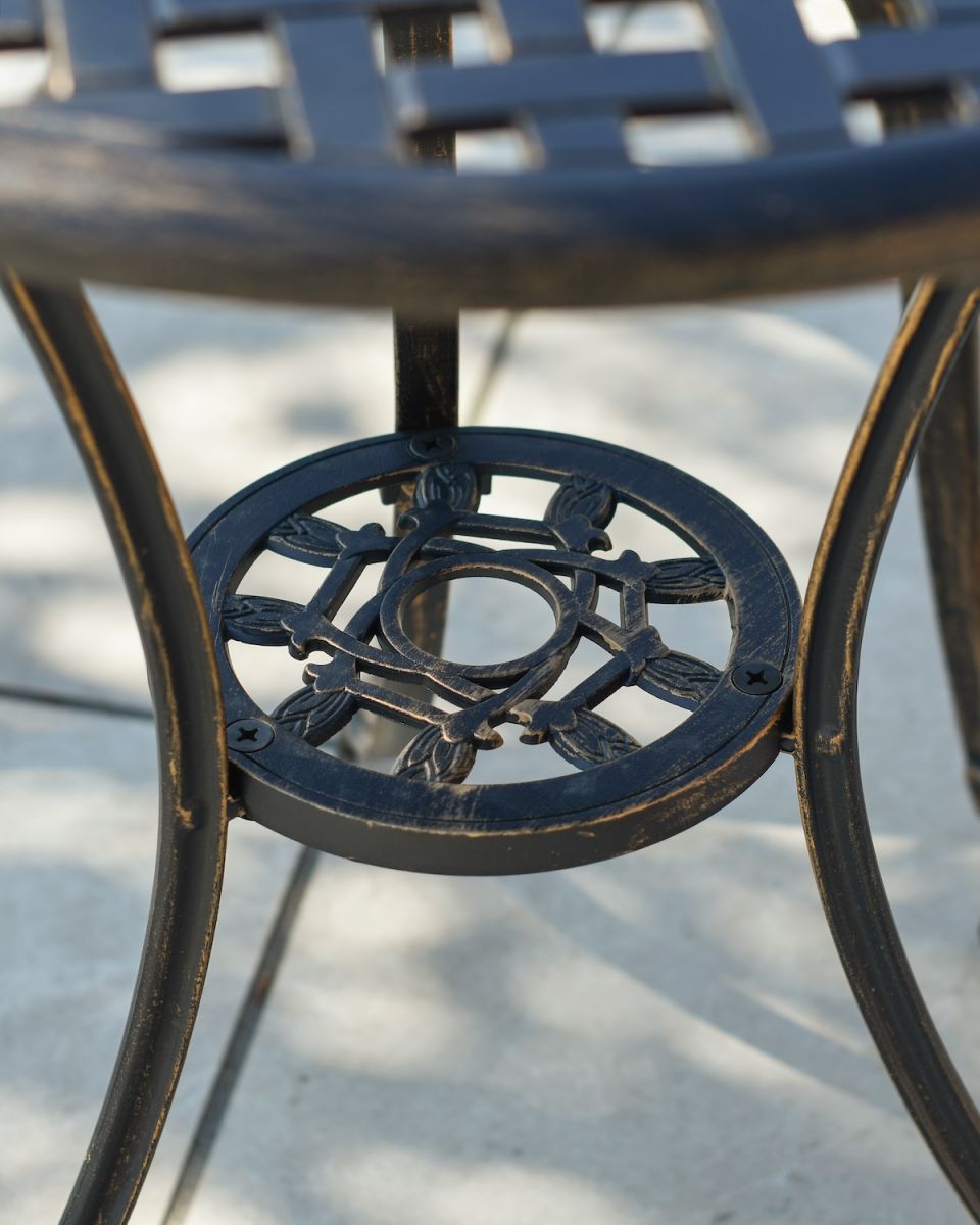 Close up of ornate table base on cast aluminium garden two seater furniture set Close up of ornate table base on cast aluminium garden two seater furniture set