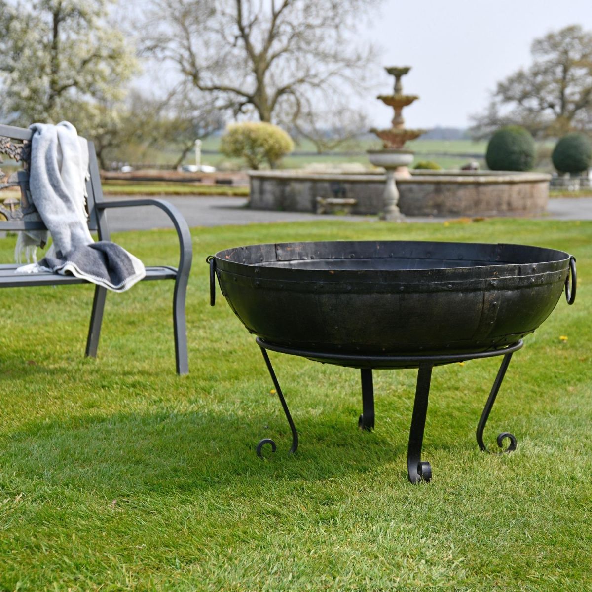 90cm Kadai Bowl in garden setting with handles down 
