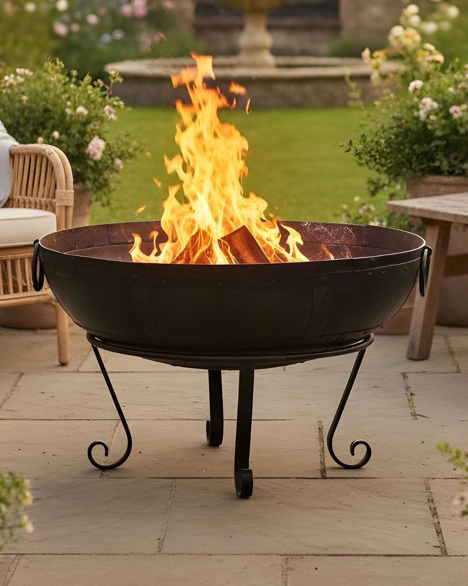 Digital Illustration of the 90cm Version of the Kadai Fire Bowl Fully Lit in Front of a Garden Lawn