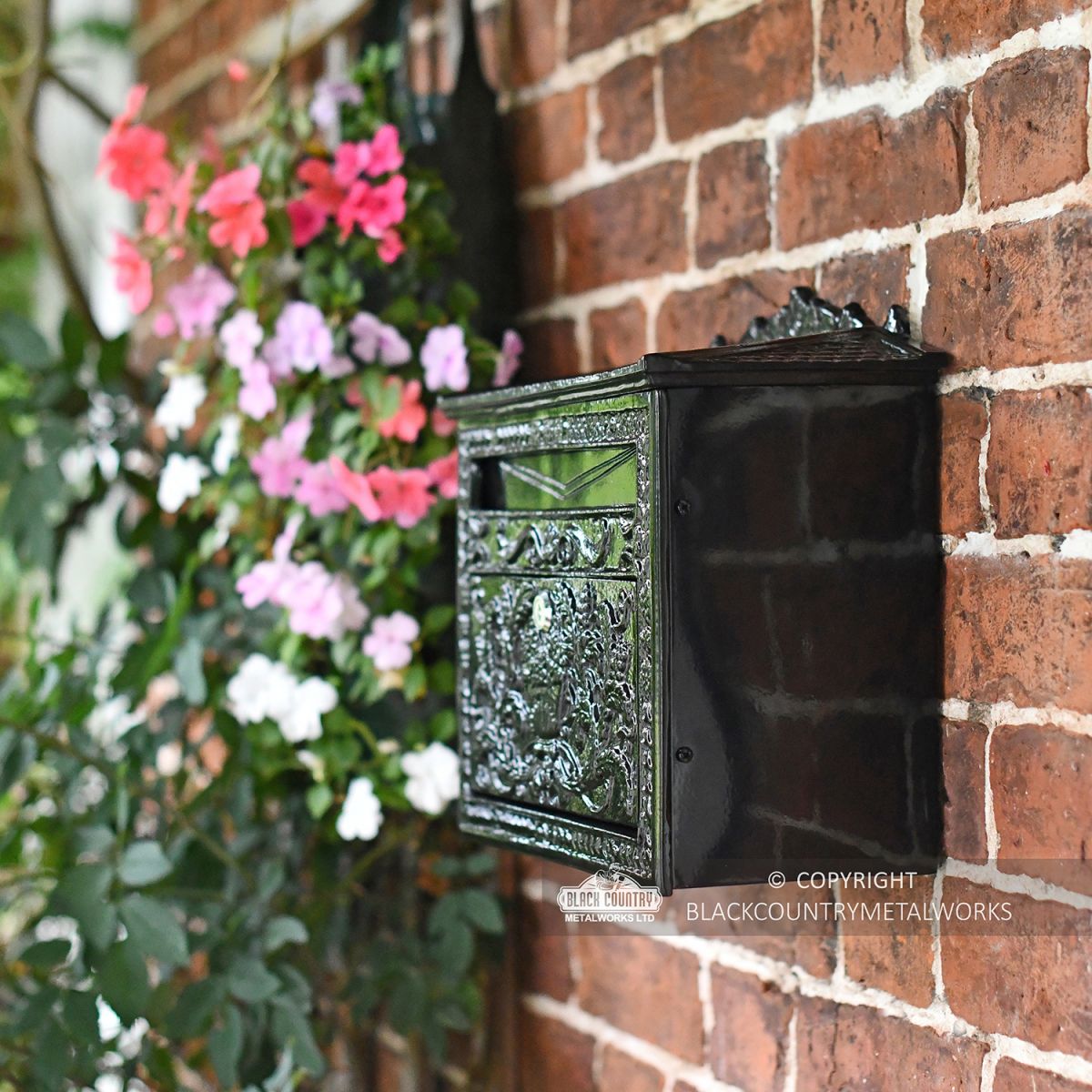 View of the Side of the "Horncastle Abbey" Black Post Box Mounted on a Brick Wall