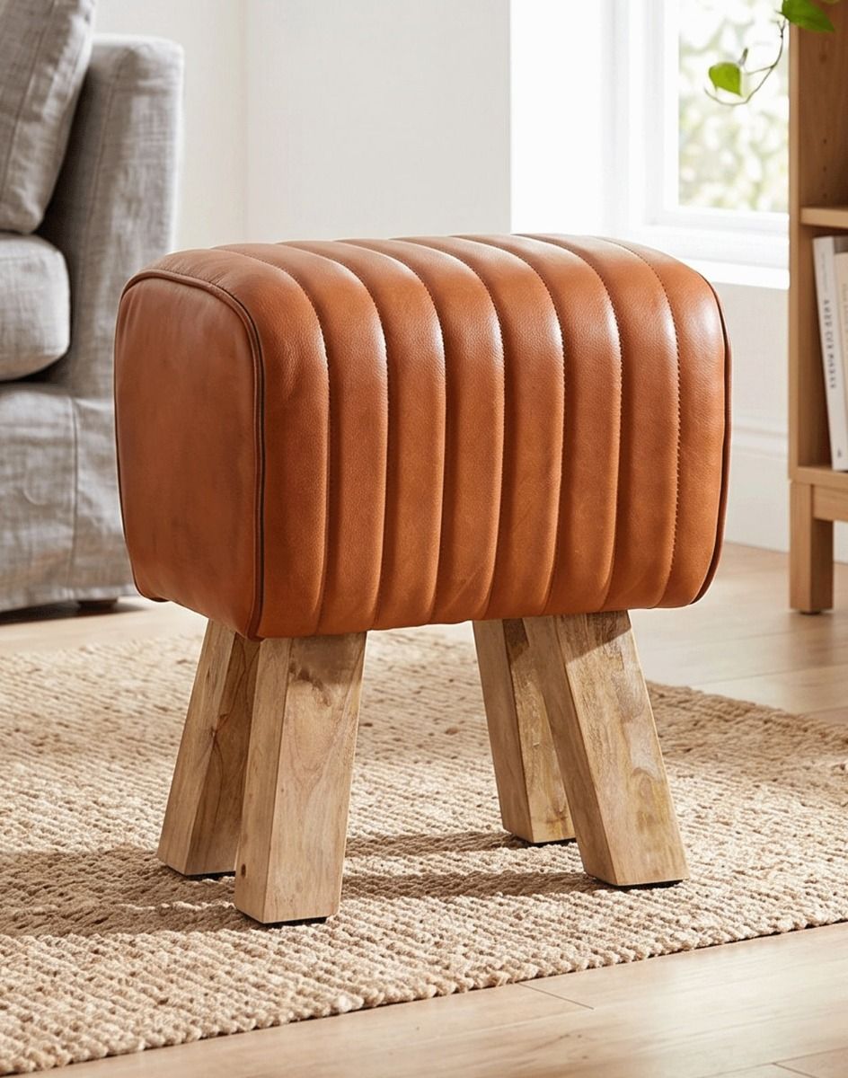 "The Orton" Mango Wood & Tan Leather Stool on a Beige Rug in a Living Room Next to a Sofa - Digital Illustration