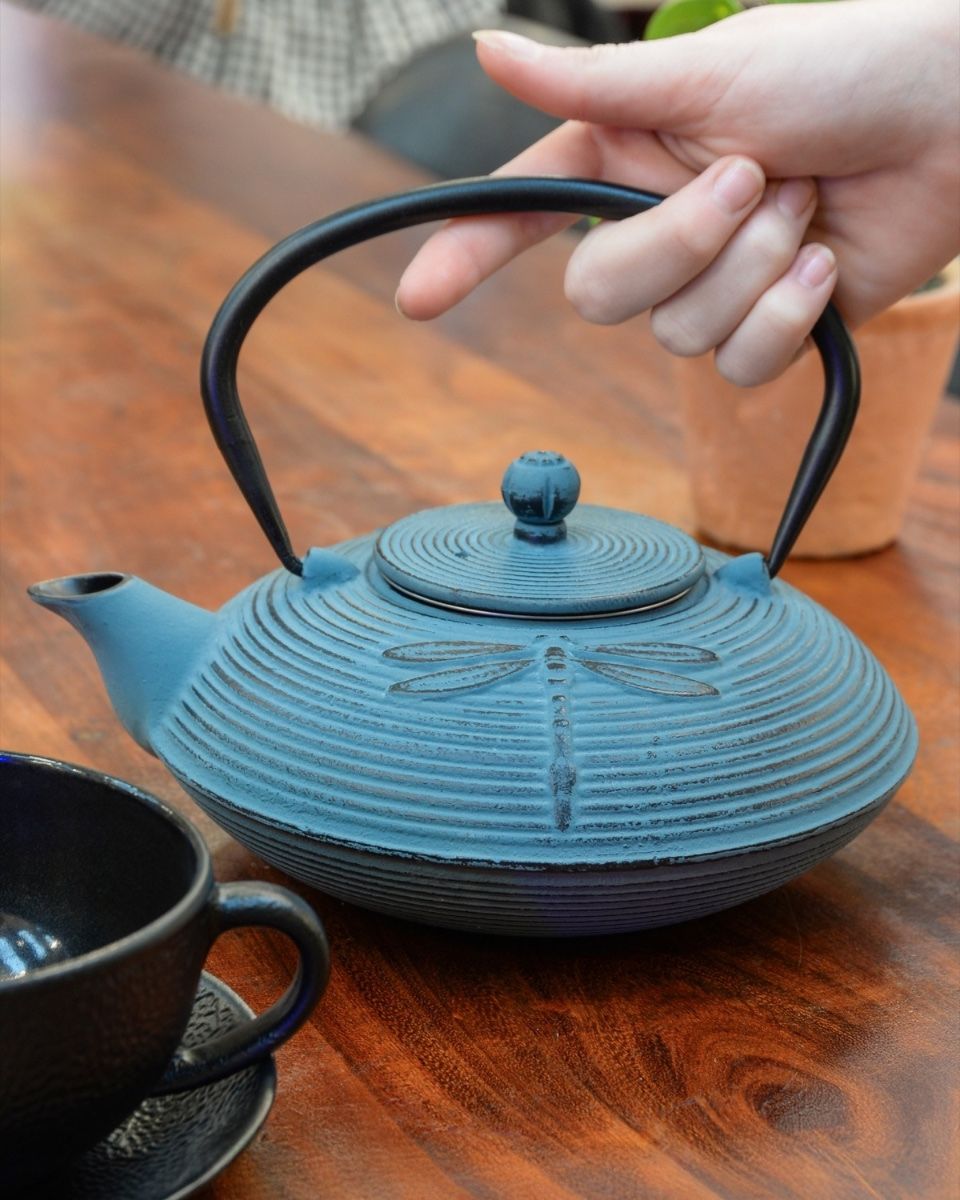 "Akitsu" Cast Iron Japanese Style Teapot in a Light Blue Finish with Hand in Shot for Scale
