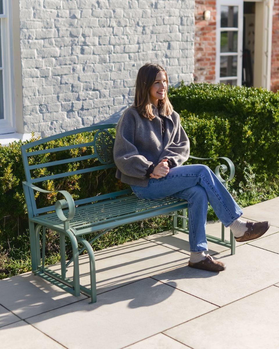 "Arcadia" Garden Rocking Bench Wrought Iron - Sage with lady sat on bench