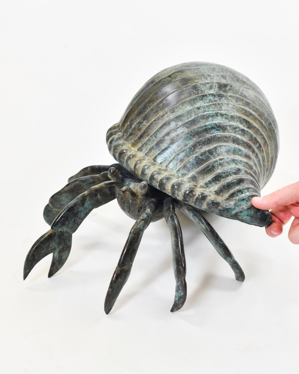 "Aurelian Nomad" Cast Brass Hermit Crab Ornament with hand in shot for scale