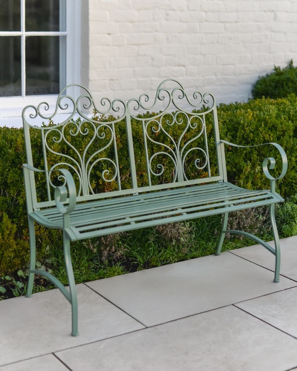 "Belvedere" Wrought Iron Garden Bench in front of hedge