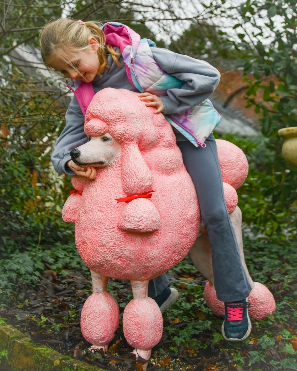 ‘Candyfloss’ the Poodle Fibreglass Garden Sculpture child sat on top petting the poodle