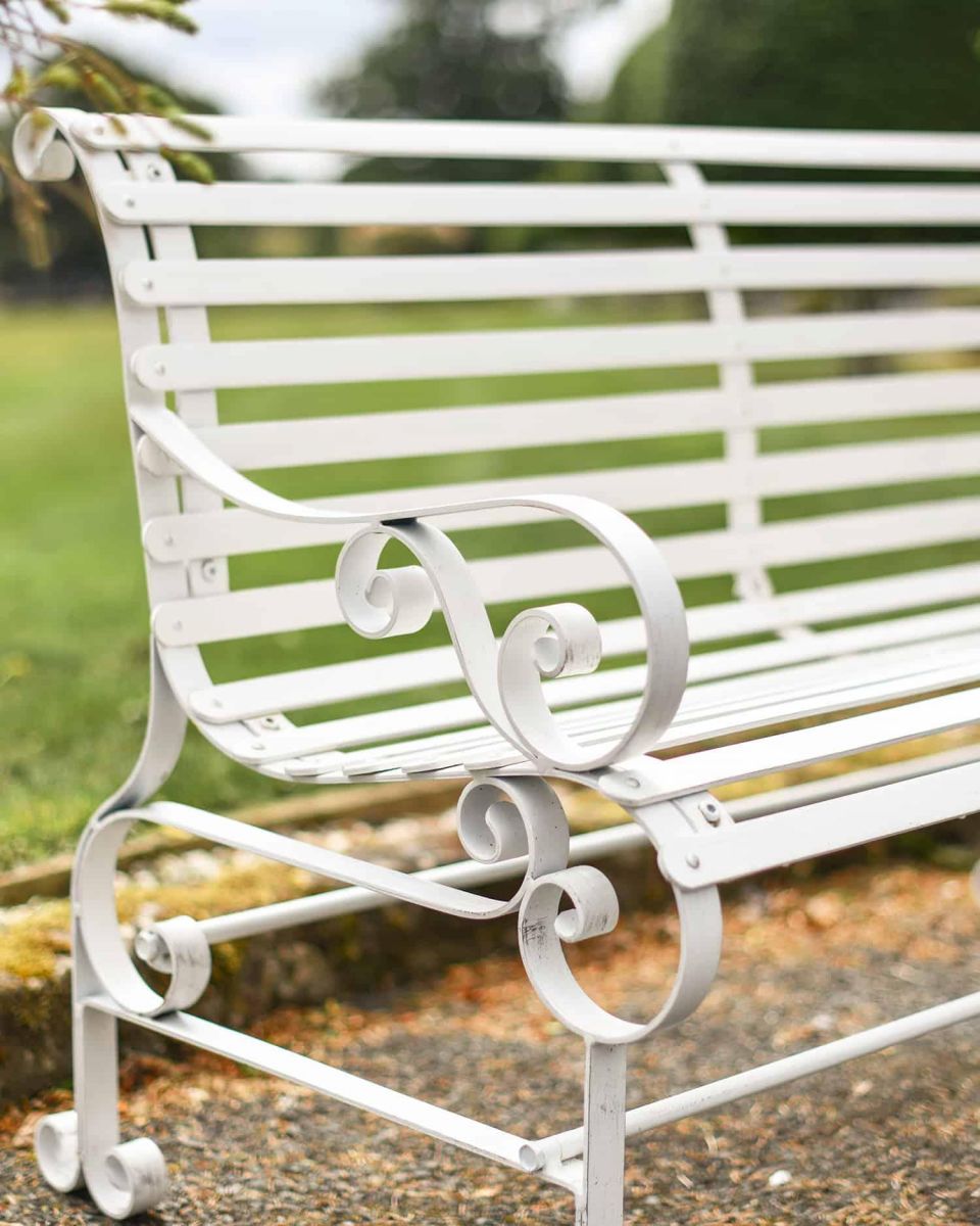 Close-Up of Ornate Armrest on Cream “Chatham" Two Seater Park Bench