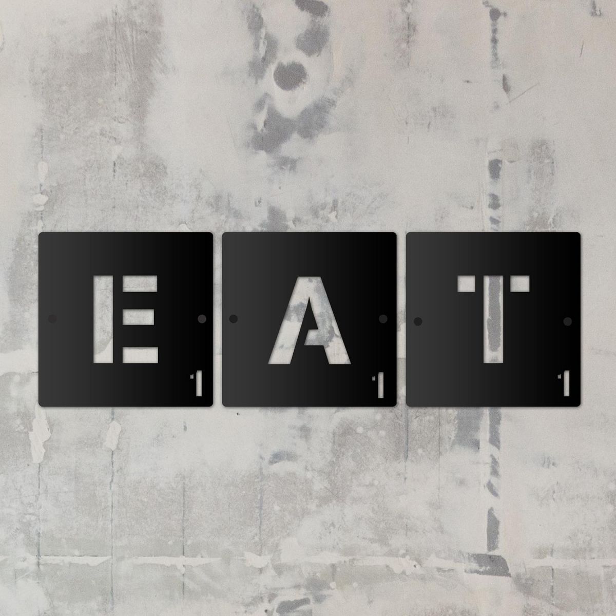 "EAT" Black Scrabble Square Letters in situ on a Rustic Wall