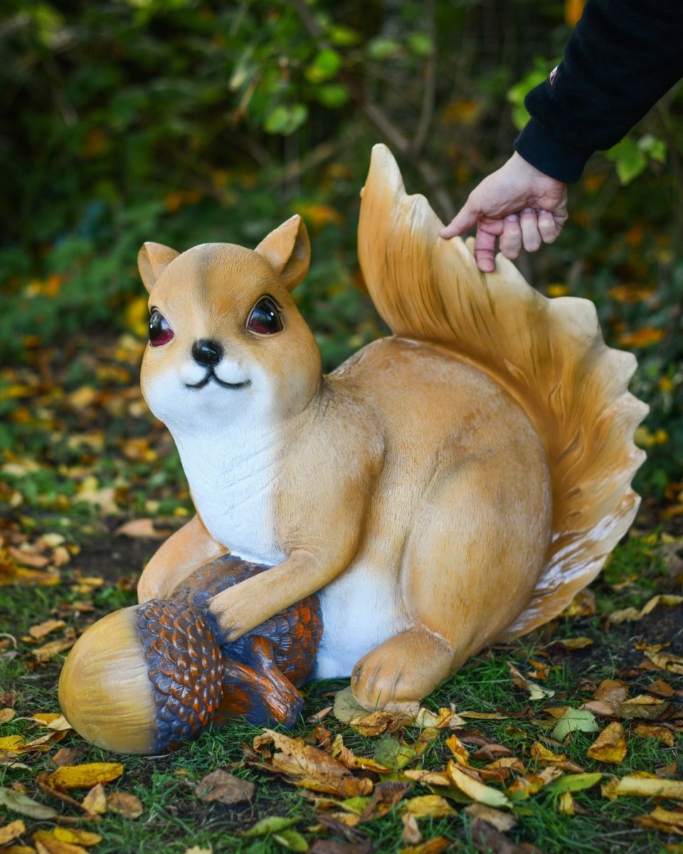"Fidget" the Handpainted Fibreglass Squirrel Garden Sculpture with hand in shot for scale