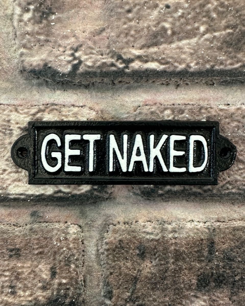 "Get Naked" Traditional Cast Iron Wall Sign mounted on abrick wall