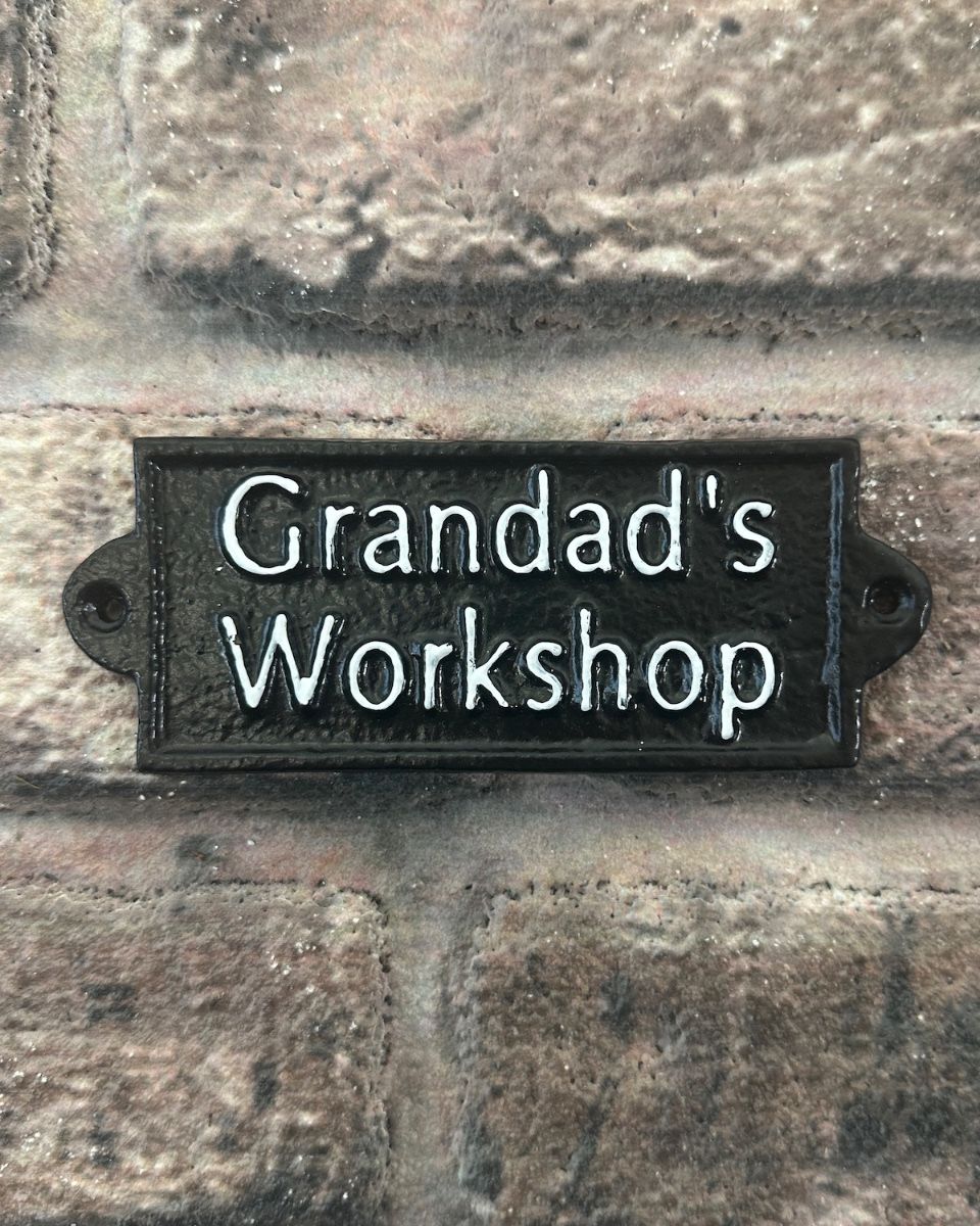 "Grandad"s Workshop" Traditional Cast Iron Wall Sign black and white mounted on a wall