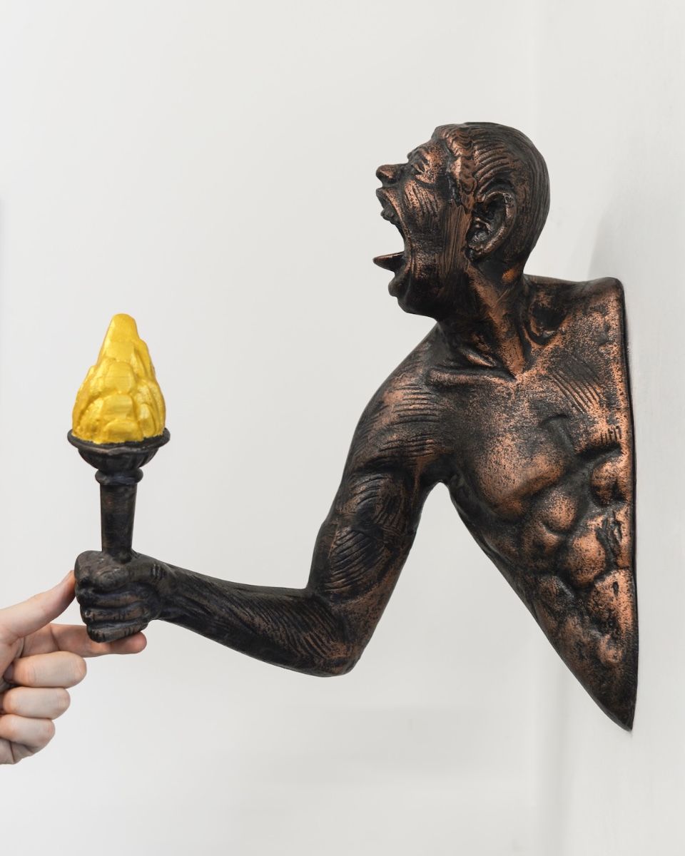 "Ignite" Cast Aluminium Wall Art in Bronze and Copper Finish with hand in shot for scale