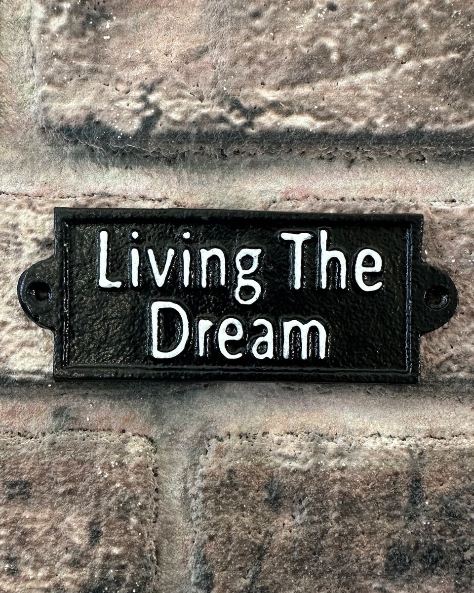 "Living the Dream" Traditional Cast Iron Wall Sign mounted on a brick wall