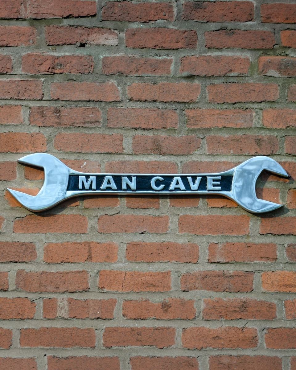 "Man Cave" Spanner Sign in Cast Aluminium Wall Art Mounted on a Brick Wall