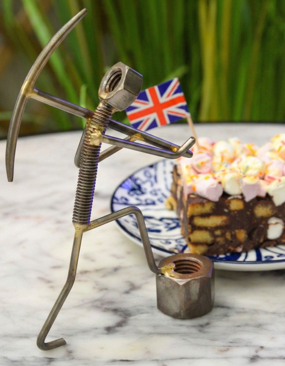 "Miner" Upcycled Metal Home Ornament holding pickaxe in front of cake