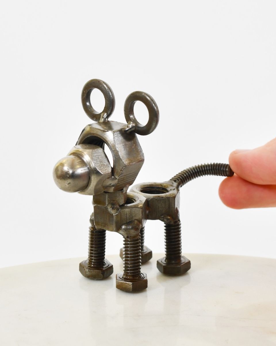"Nuts" Standing Puppy Upcycled Metal Home Ornament with hand in shot for scale