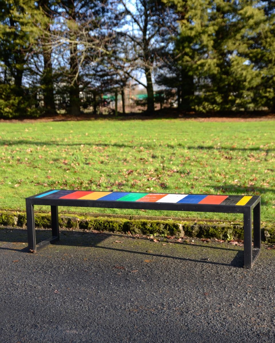 "Prism" Upcycled Oil Drum Garden Bench stood in front of lawn