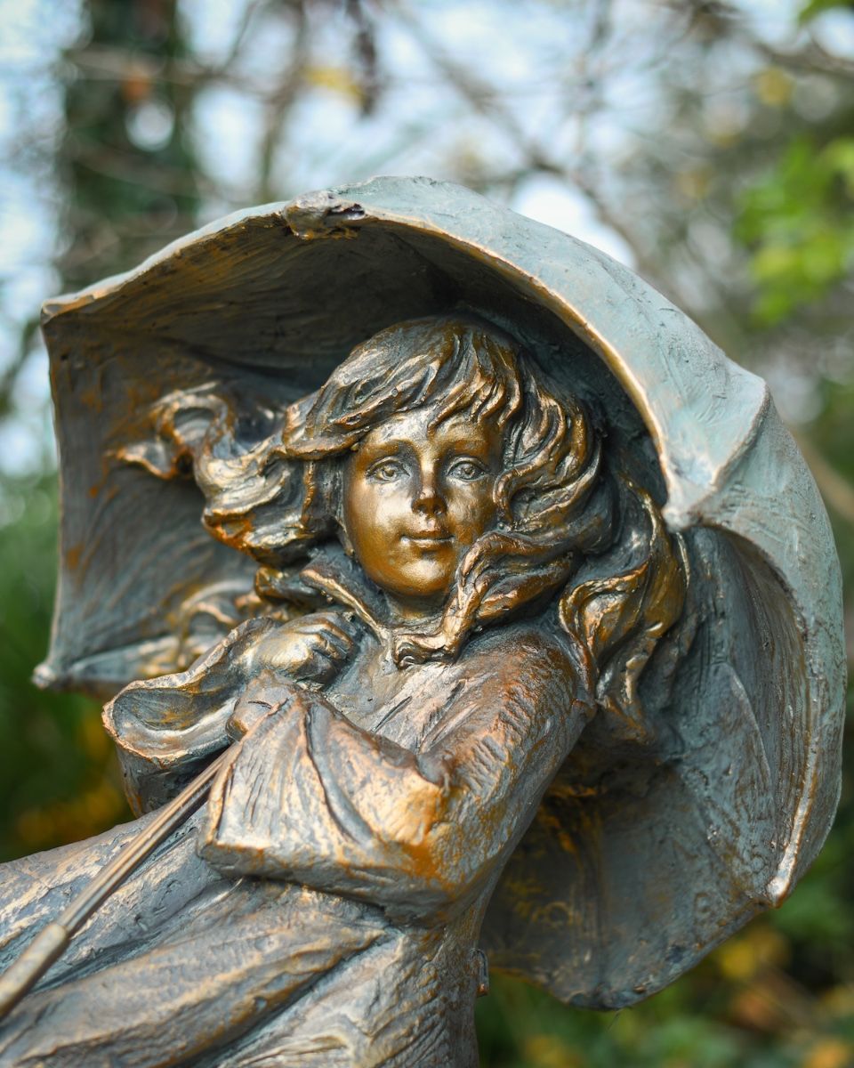 "Rain or Shine" Girl with Umbrella Resin Garden Sculpture Brass and Verdigris Finish close up of head